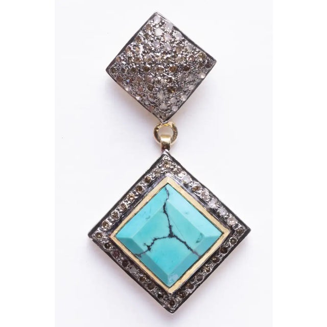 Pave` set diamonds adorn the post of these drop earrings and also border the beveled square turquoise stones set on the...