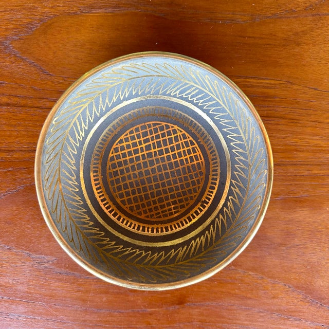 This is an art-deco style gold and stone gray dish made by Waylande Gregory. The exterior of the bowl is all gray while...