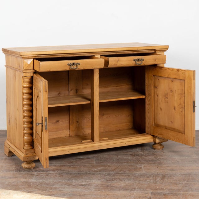 Danish pine sideboard with carved arches along two front door panels. Doors are flanked by elaborate turned half columns...