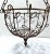 A substantial 1950s wrought iron hanging basket featuring curled scrollwork, petal and leaf detailing, and original chain...