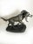 French terracotta sculpture dating from the 19th century, depicting a hunting dog carrying a game bird in its mouth. The...