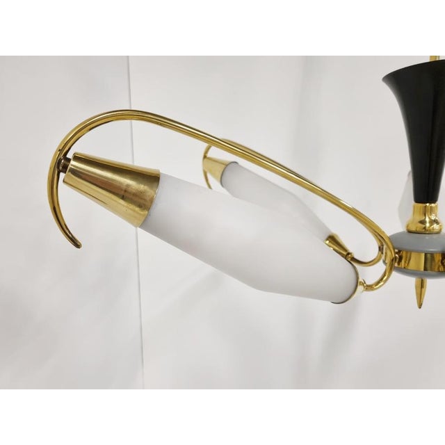 Mid century brass chandelier with 5 arms and white glass shades. Striking design and it emits a beautiful light. Good...