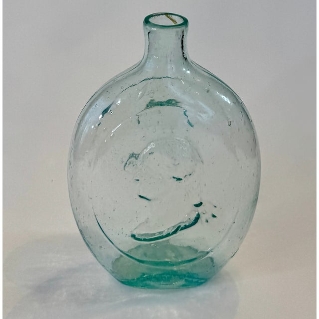 Antique American historical flask in aqua glass, circa 1850, featuring molded relief portraits of George Washington and...