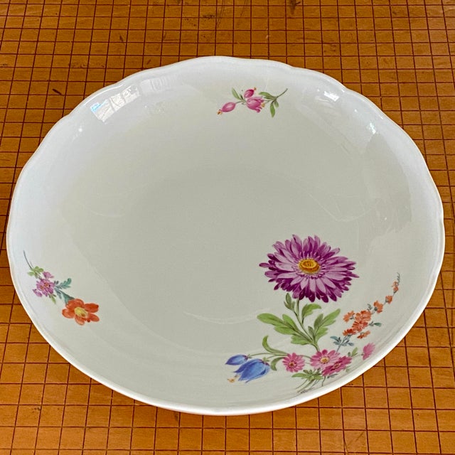 Meissen scalloped edge 9 1/2 inch floral motif serving bowl. With a large hand painted purple/pink flower and smaller...