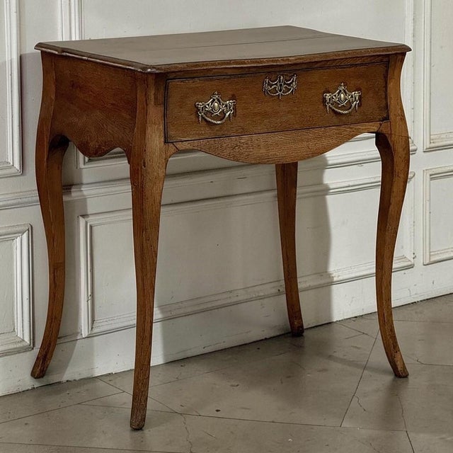 Crafted in the Netherlands during the 18th century, this charming antique oak end table captures the graceful movement and...