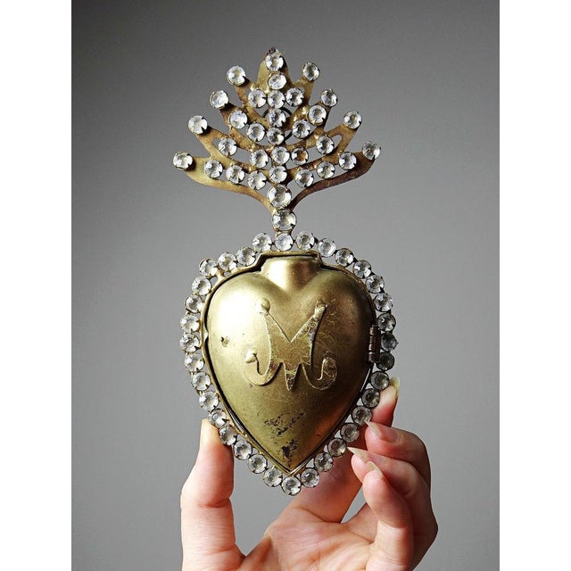 A very beautiful ex-votive wall box depicting the flaming heart of the Virgin Mary, made of gilt metal with a tassel, set...