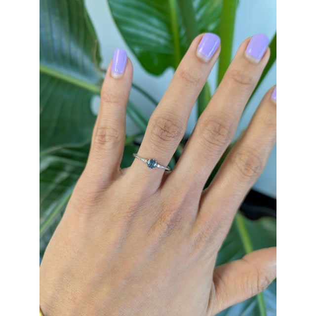 A natural color-change alexandrite sits at the center of this solid 14K white gold ring, flanked by four earth-mined...