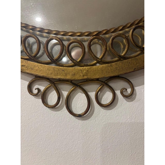 A round mirror of timeless elegance, its forged and gilded metal frame evoking the grace of the 1950s. A continuous frieze...