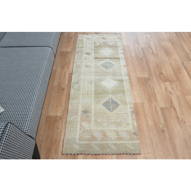 Vintage Hand-Knotted runner rug is a semi-antique vintage area rug. The '70s Eastern region of Anatolia's unique rug is...