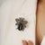 This whimsical 15.35 carat emerald, citrine, and diamond beetle brooch pendant is crafted in 925 sterling silver....