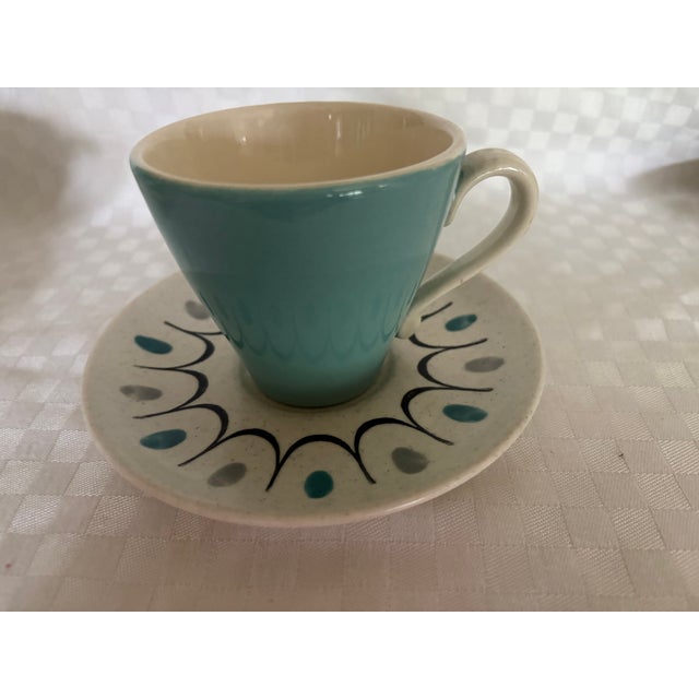 A set of 8 Metlox cups and saucers in the Poppyfield pattern. The cups are turquoise on the outside and white in the...