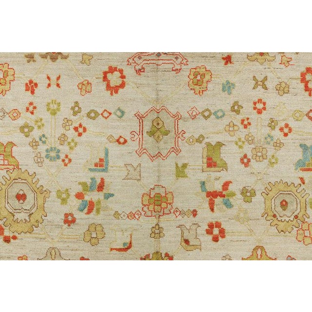 An enormous Turkish Oushak in candy color accents on a bone color ground. Full pile excellent condition. Measures: 14'5''...