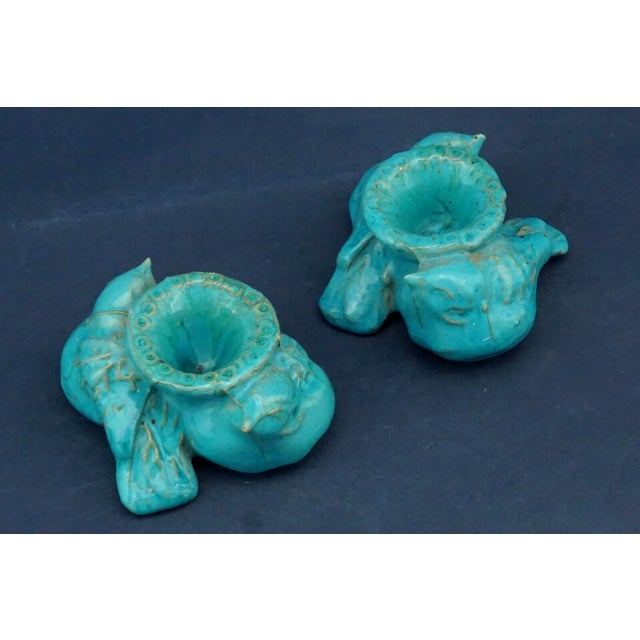 A stunning pair of candle holders, consisting of two sculptures featuring a pair of birds, specifically sparrows, entirely...