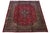 This vintage Mashad Persian wool rug features a red field with a navy blue frame and multicolored accents. This rug...