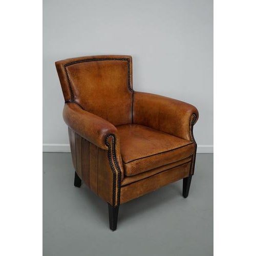 This cognac-colored leather club chair comes from the Netherlands. It is upholstered with cognac-colored leather and...