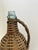 Tall glass bottle wrapped in wicker.