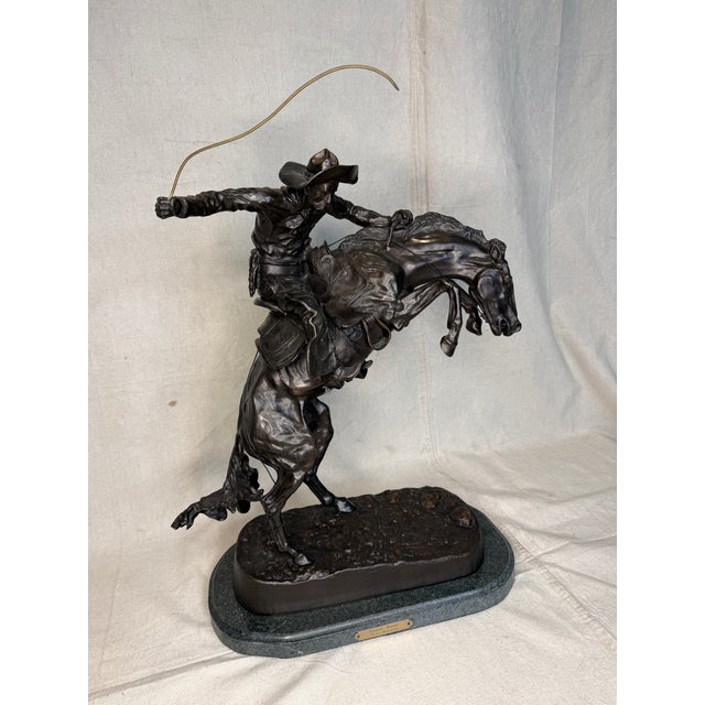 A dramatic and iconic rendering of Frederic Remington’s celebrated Western masterpiece, “The Bronco Buster.” This...