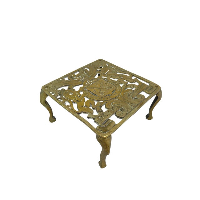 Antique solid brass trivet with family crest motif. No maker's mark. Minimal age wear.