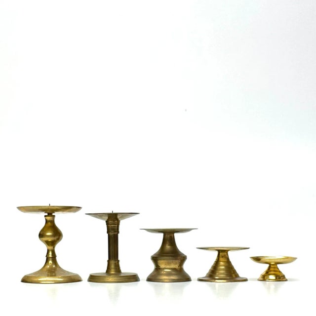 Brass candle holder curation, group of 7. This is a festive group of brass pillar candle holders featuring a variety of...