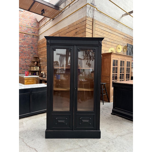This antique display cabinet made of walnut and oak has been fully restored. It features a black-patinated cabinet body,...
