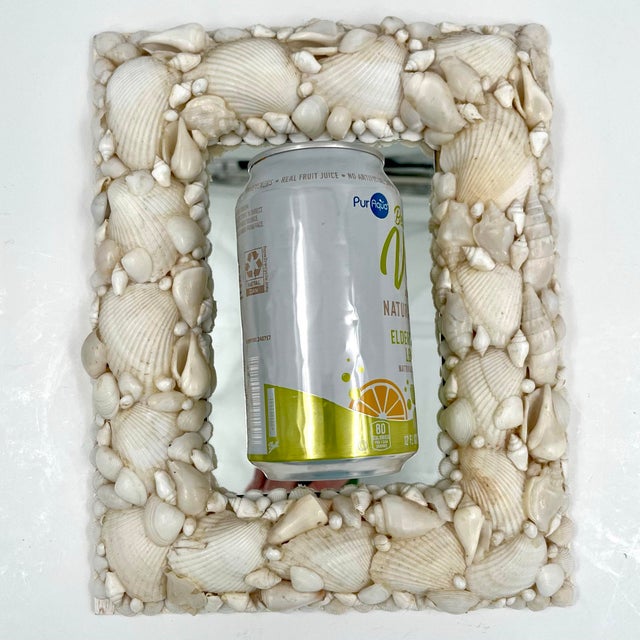 This beautiful vintage rectangular shell-encrusted mirror features a wood back and a hook for hanging. It can also be...