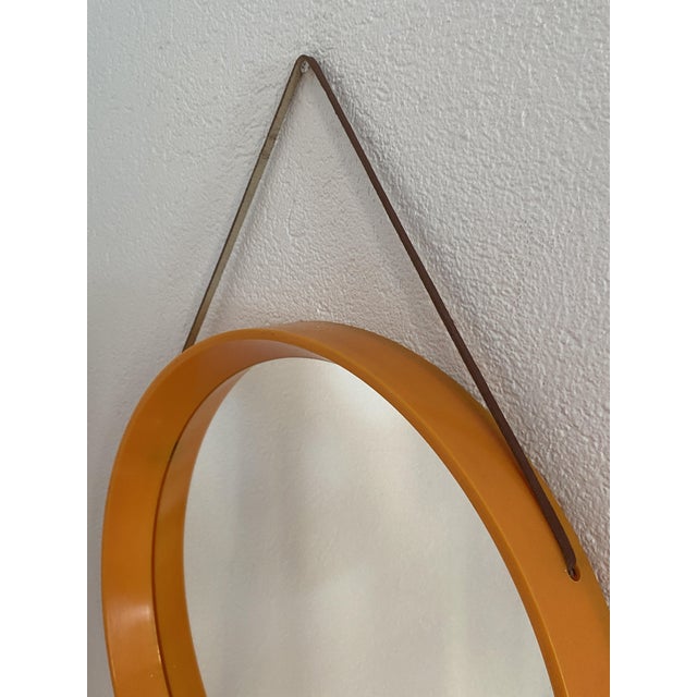 Danish Space Age style mirror produced in the 1970s. Plastic frame with original leather cord for hanging. Very pop orange...