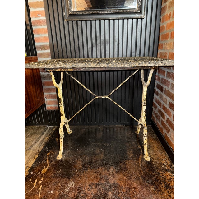 This antique French bistro table features a naturally weathered cream and ochre yellow cast iron base paired with a dense,...