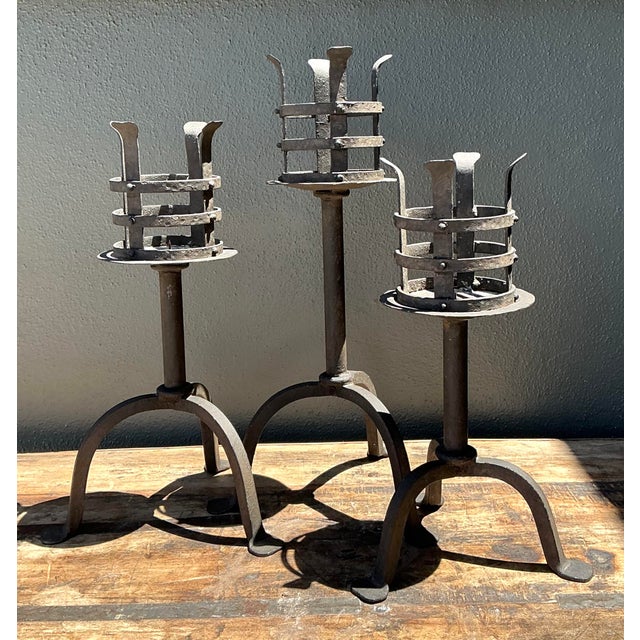 This set of three hand-forged wrought iron candlesticks showcases the rugged artistry of Spanish Revival design. Each...