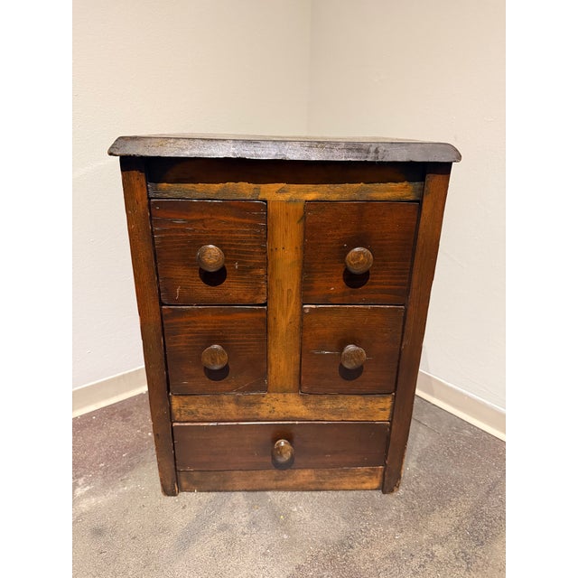 Charming vintage primitive wood apothecary-style cabinet featuring four individual upper drawers and one larger lower...