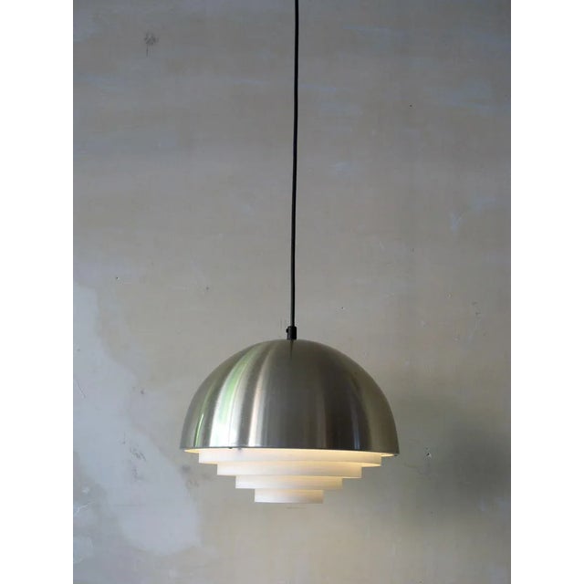 This mid-century pendant light was manufactured in Denmark in the 1960s. Made from brass and metal, the main body of the...