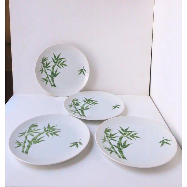 A set of four (4) white porcelain plates (salad plate size) with a linen-like surface and green bamboo design, circa...