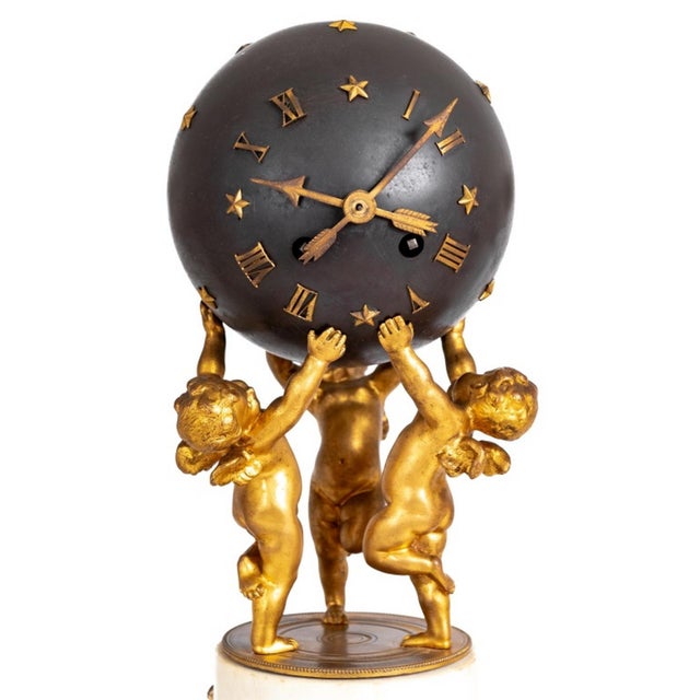 Louis XVI Style Patinated and Gilt Bronze and White Marble Three Piece Clock Set, late 19th century, comprising a globe...