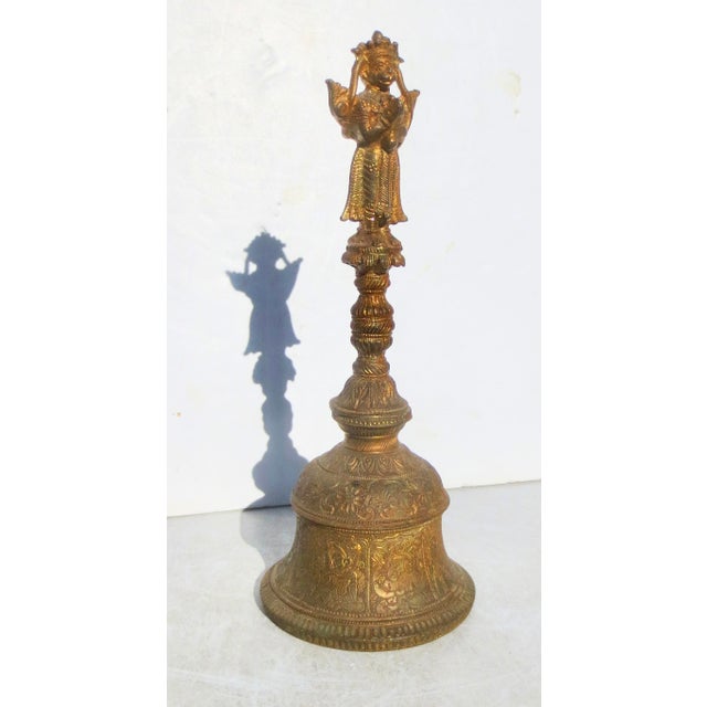 Indian bronze temple bell with Hanamun and Garuda handles. Engraved bell with multiple deities around the outer walls....