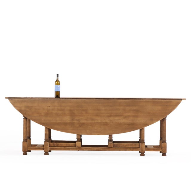 A substantial and well-crafted Belgian oak gateleg table featuring a classic oval top with two drop leaves. The expansive...