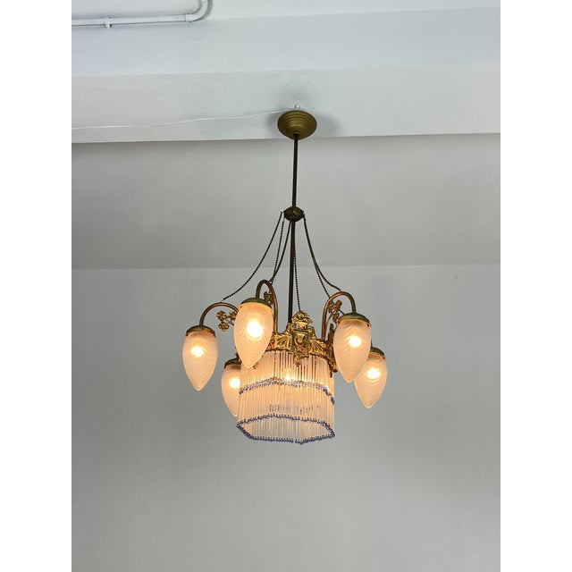 7-light Art Deco chandelier in brass and glass, 1940s Six arms, colored fringe. E27 bulbs. Good condition, small signs of...