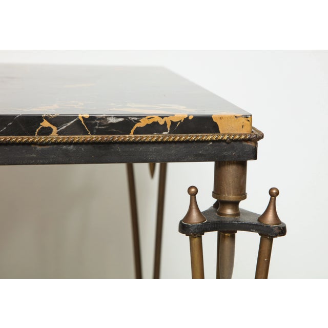Bespoke coffee table designed in the style of Gilbert Poillerat, base of bronze and iron with gold and black marble top.