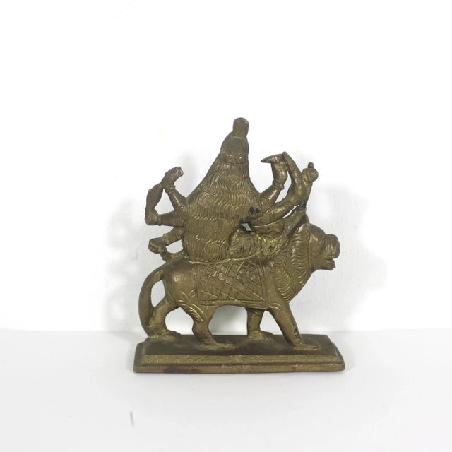 This is a brass statue of the Hindu goddess Durga riding a lion. Durga is a major deity in Hinduism, known as the warrior...