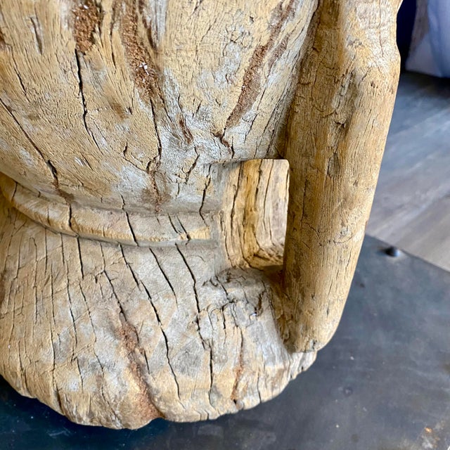 A striking study in form and patina, this 19th-century rustic hand-carved wood mortar is presented on a custom display...