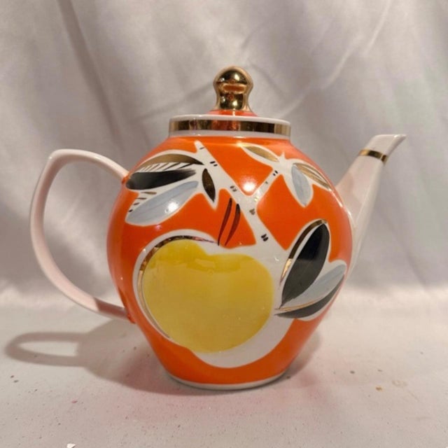 A vintage 1970's era porcelain tea pot in vibrant orange and yellow fruit motif with 24k trim. About 7"H x 6" W in Unused...