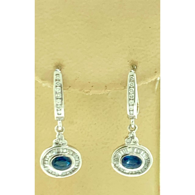 Approximately 0.7 Ct Natural Blue Sapphire and 0.75 Ct Diamond Huggie Earrings 14 Karat Gold A fabulous pair of earrings...