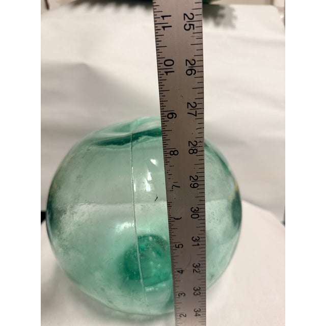 This large aqua glass fishing float is a unique decorative piece with a charming antique look. Measuring approximately 9...
