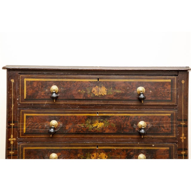 An antique four-drawer chest of drawers hand painted to imitate burl wood grain panels with dark banded and gilded...