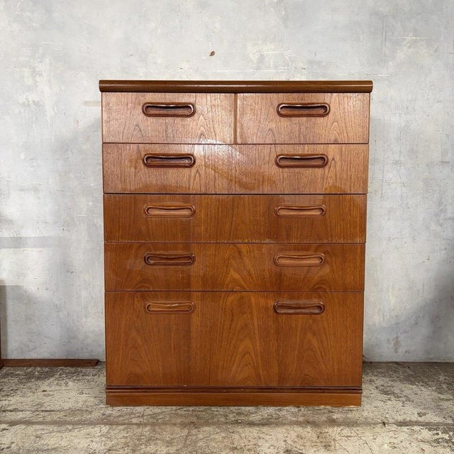 stylish mid-century teak tallboy chest of drawers by British furniture manufacturer Meredew, featuring beautifully figured...