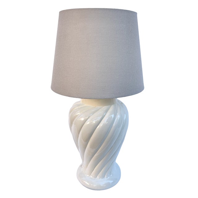 Table lamp with a classic round form with a unique groove. The body of the lamp is made of ceramic covered with white...