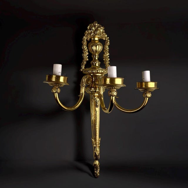 A refined french louis xvi style gilt-bronze wall sconce, crafted in the mid-20th century (1950s–60s). the sconce features...