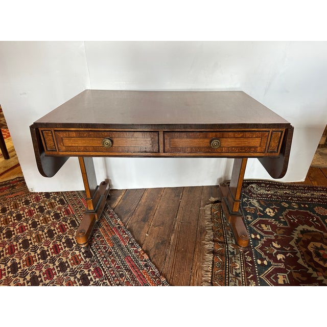 Drop leaf sofa table or desk having richly grained wood, two drawers on one side and two dummy drawers on the other side...