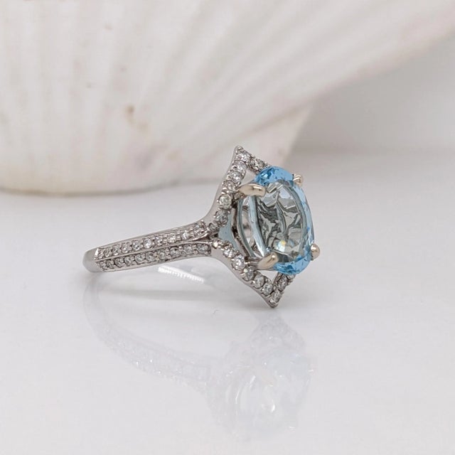 This statement ring features a brilliant blue oval aquamarine encased in a halo of natural earth mined diamonds. Made in...