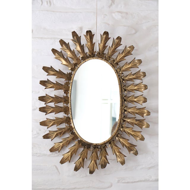 Gilt metal sunburst mirror, Spanish work dating from the 1960s. The particularly refined decoration consists of acanthus...