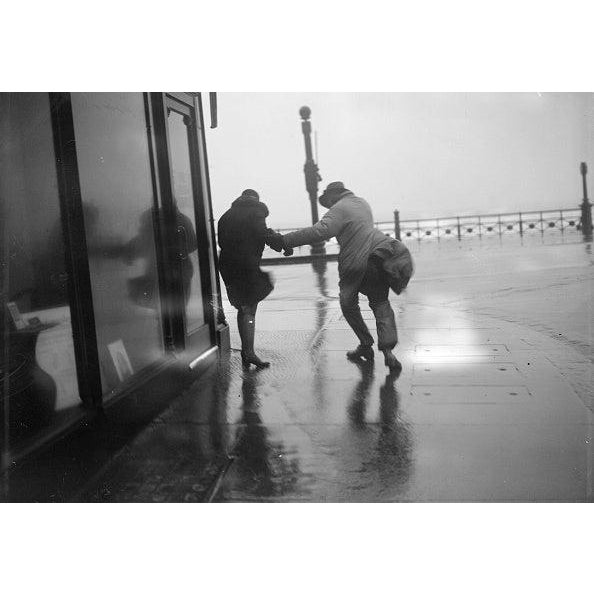 Gale On Pier A couple holding hands on the pier at Brighton during a gale. (Photo by Fox Photos/Getty Images) Paper size:...