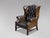 A high-quality, early 20th-century Edwardian period brown leather full-button wing armchair in the George III style. The...
